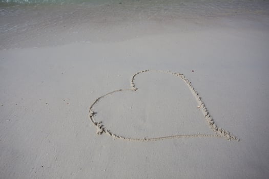 hearts drawn on the sand of a beach photo