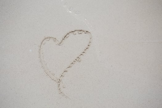 hearts drawn on the sand of a beach photo