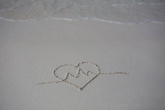 hearts drawn on the sand of a beach photo