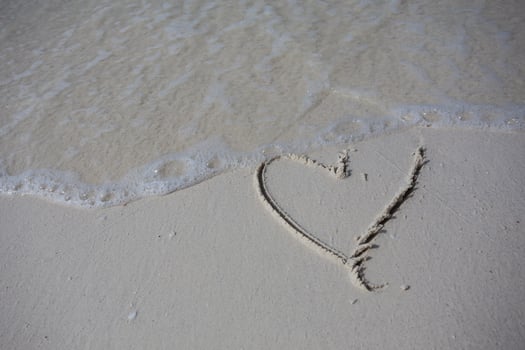 hearts drawn on the sand of a beach photo