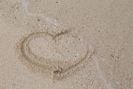 hearts drawn on the sand of a beach photo