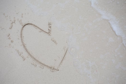 hearts drawn on the sand of a beach photo
