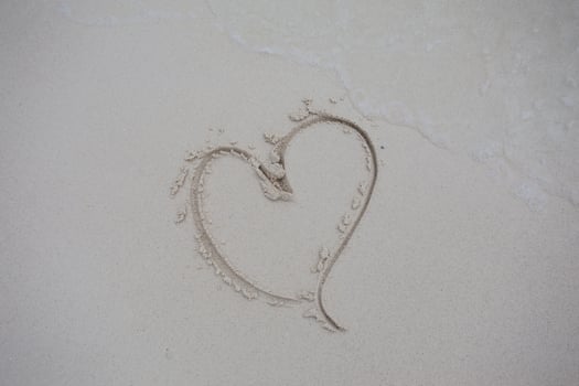 hearts drawn on the sand of a beach photo