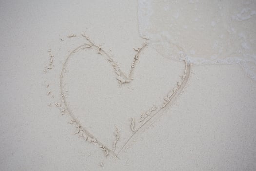 hearts drawn on the sand of a beach photo