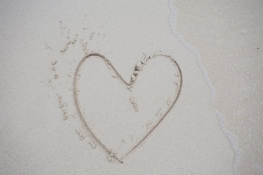 hearts drawn on the sand of a beach photo