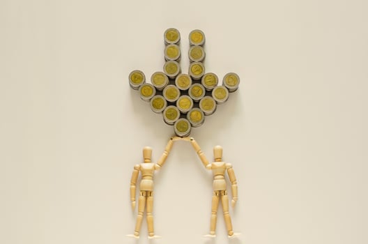 Two wood models carrying Thai baht coins that set as down arrow. photo
