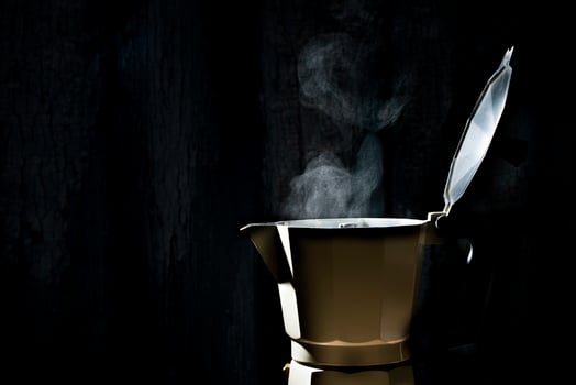 Moka pot with smoke on black background.soft focus. photo