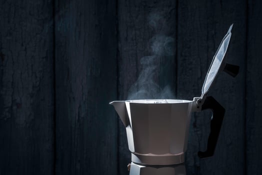 Moka pot with smoke on black background.soft focus. photo