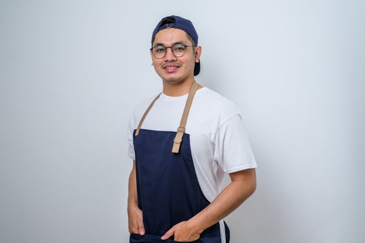 Portrait of young Asian barista smiling, wearing apron photo