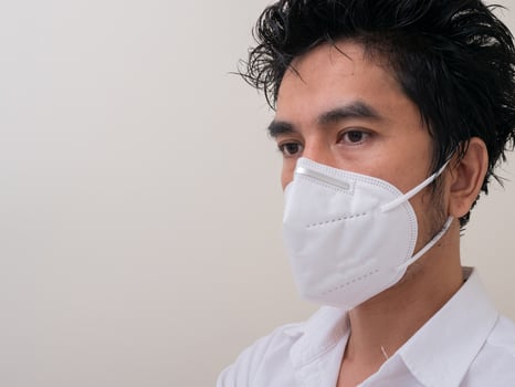Asian young man in white shirt and medical mask to protect COVID-19 photo