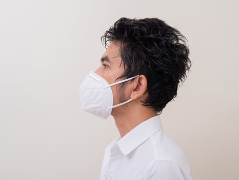 Asian young man in white shirt and medical mask to protect COVID-19 photo