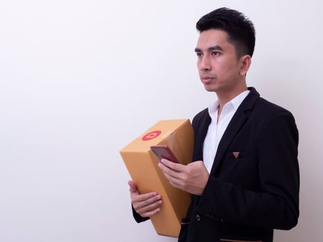 Shipper young Asian man holding cardboard box photo