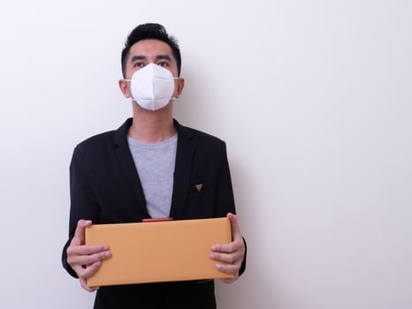 Happy delivery service employee in medical face mask carry cardboard box in hand photo