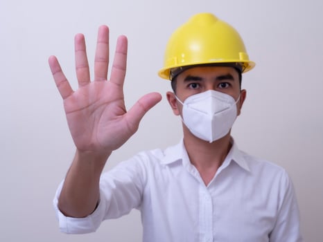 Asian industrial workers wear yellow hard hats, wear protective masks for their health photo
