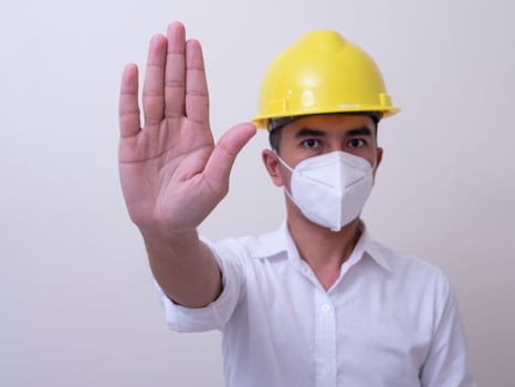 Asian industrial workers wear yellow hard hats, wear protective masks for their health photo