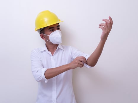 Asian industrial workers wear yellow hard hats, wear protective masks for their health photo