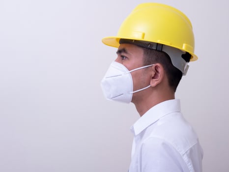 Asian industrial workers wear yellow hard hats, wear protective masks for their health photo