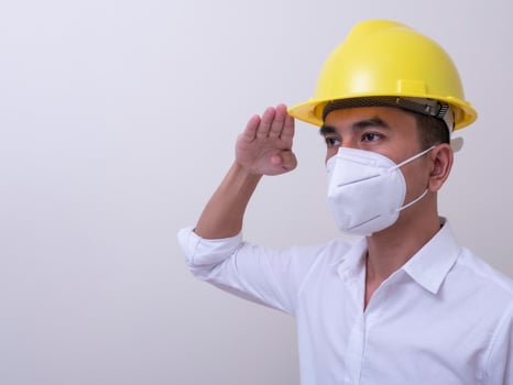 Asian industrial workers wear yellow hard hats, wear protective masks for their health photo