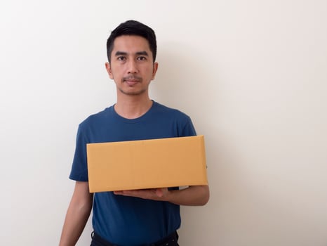 young man holding a box isolated on a white background photo