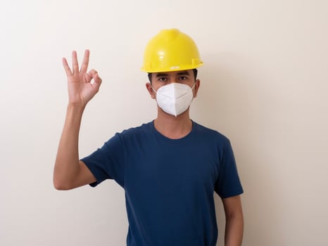 Asian industrial workers wear yellow hard hats, wear protective masks for their healtha photo