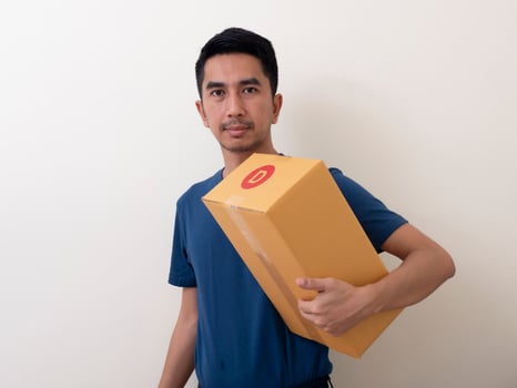 man wearing surgical mask with cardboard box on a white background photo