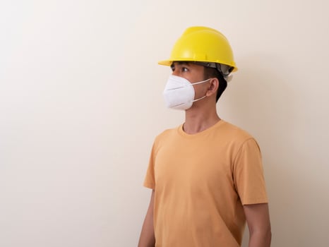 Asian industrial workers wear yellow hard hats, wear protective masks for their health photo