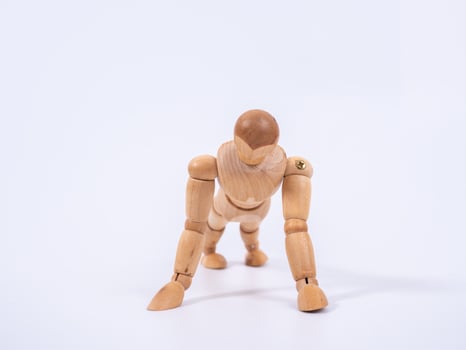 Small wooden dummy during push ups on white background photo