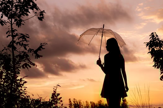 Silhouette woman holding an umbrella at the sunset time photo