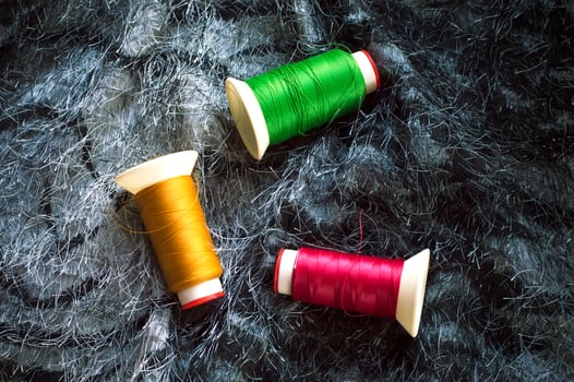 Sewing background. Accessories for needlework. Colorful threads on black fabric background. photo