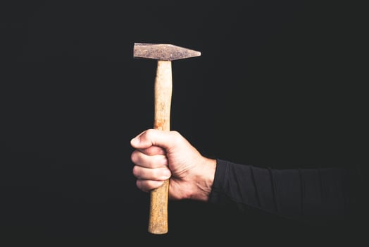hammer in a man hand on black background - maintenance service concept photo