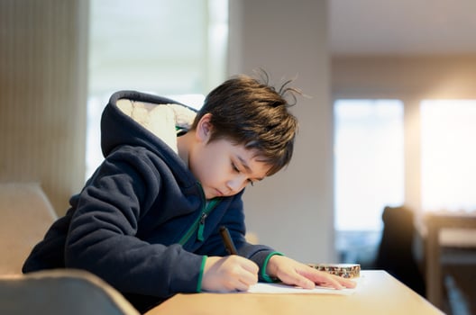 School kid using black pen drawing or writing the letter on paper, Young boy doing homework, Child with pen writing notes in paper sheet during the lesson.Cute pupil doing test, Homeschooling concept photo