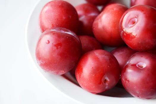 Juicy fresh red plums on a white background photo