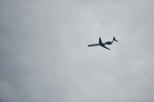 Passenger plane high up in the sky. Cloudy weather. Modern aviation photo