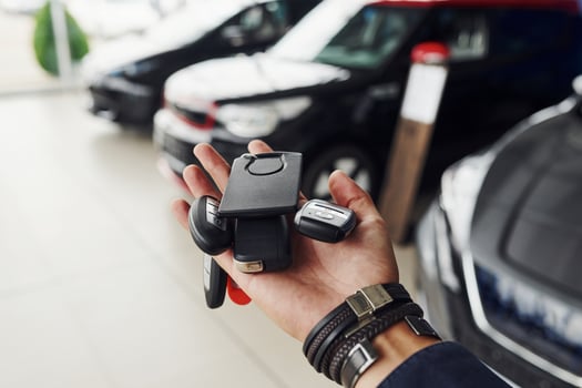 Keys from the cars lying on man's hand. Indoors in auto salon photo