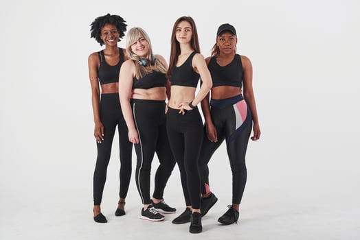 Calm cheerful people. Group of multi ethnic women standing in the studio against white background photo