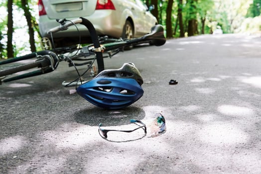 Conception of carelessness. Bicycle and silver colored car accident on the road at forest at daytime photo