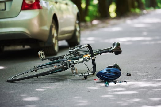 No people. Bicycle and silver colored car accident on the road at forest at daytime photo