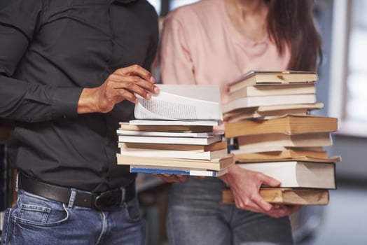 Standing in casual clothes. Multiracial students in the library searching for the information together photo