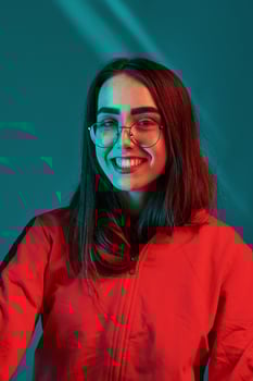 Sincere smile. Studio shot indoors with neon light. Portrait of beautiful young girl photo