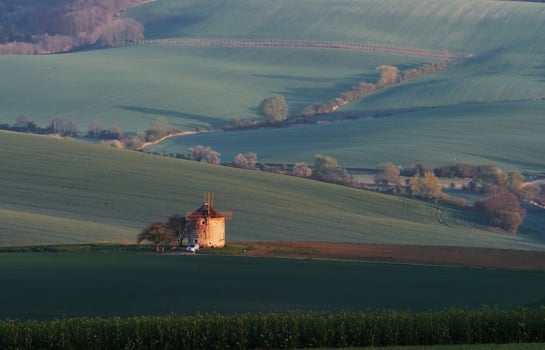 Majestic landscape of field in the evening. Windmill in the center of meadow photo