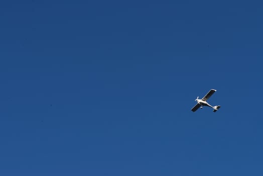 Biplane flying high in the blue sky at sunny day. Speed and energy photo