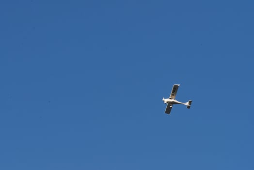 Biplane flying high in the blue sky at sunny day. Speed and energy photo