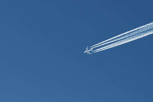 Modern plane flying high in the blue sky at sunny day. Speed and energy photo