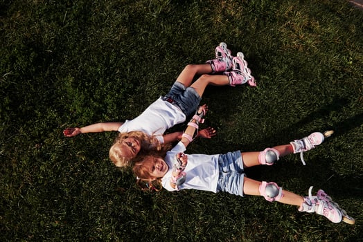 Top view. Feeling freedom. Two female kids lying on the green grass at summertime photo
