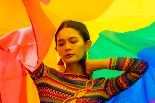Elegance transgender model woman in colorful rainbow flag costume is dancing in homosexual parade for LGBTQ pride month and coming out of the closet concept for sexual equality and freedom concept photo