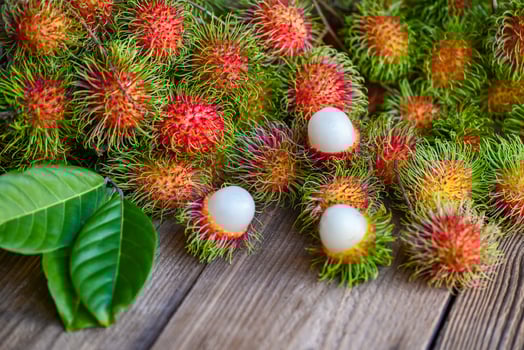 Rambutan fruit on wooden background harvest from the garden rambutan tree, Fresh and ripe rambutan sweet tropical fruit peeled rambutan with leaf photo