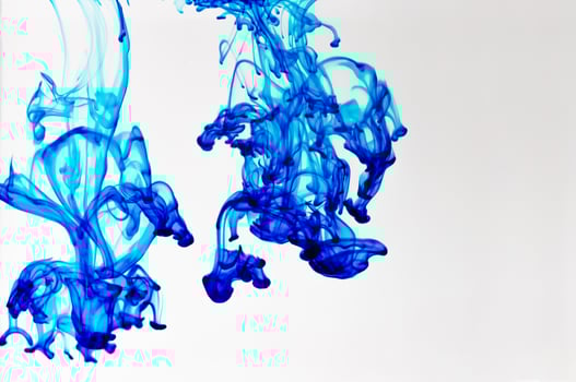 Blue food color drop in water on white background. photo