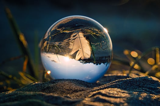Glass ball on the beach of the Baltic Sea in Zingst with a feather depicted in the ball with the landscape. photo