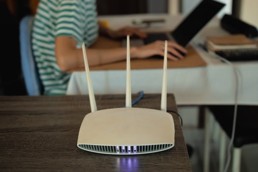 A woman is working at home using a modem router, connecting the Internet to her laptop. photo