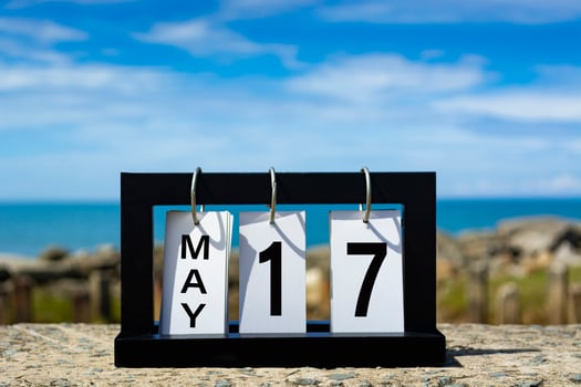May 17 calendar date text on wooden frame with blurred background of ocean. photo